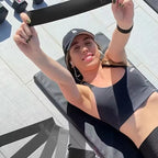 Kvinde træner med Fitvect-elastikker på et flisebelagt gulv