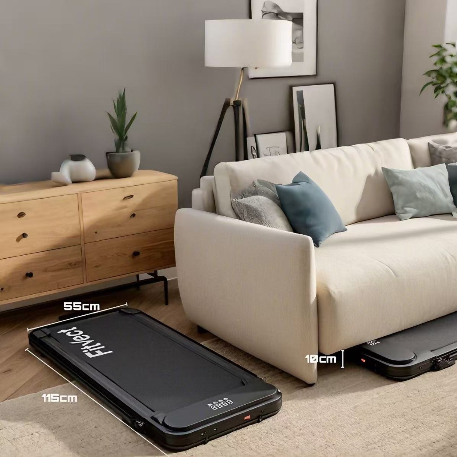 Sort kuffert på et trægulv med en beige sofa og et træskab i baggrunden.